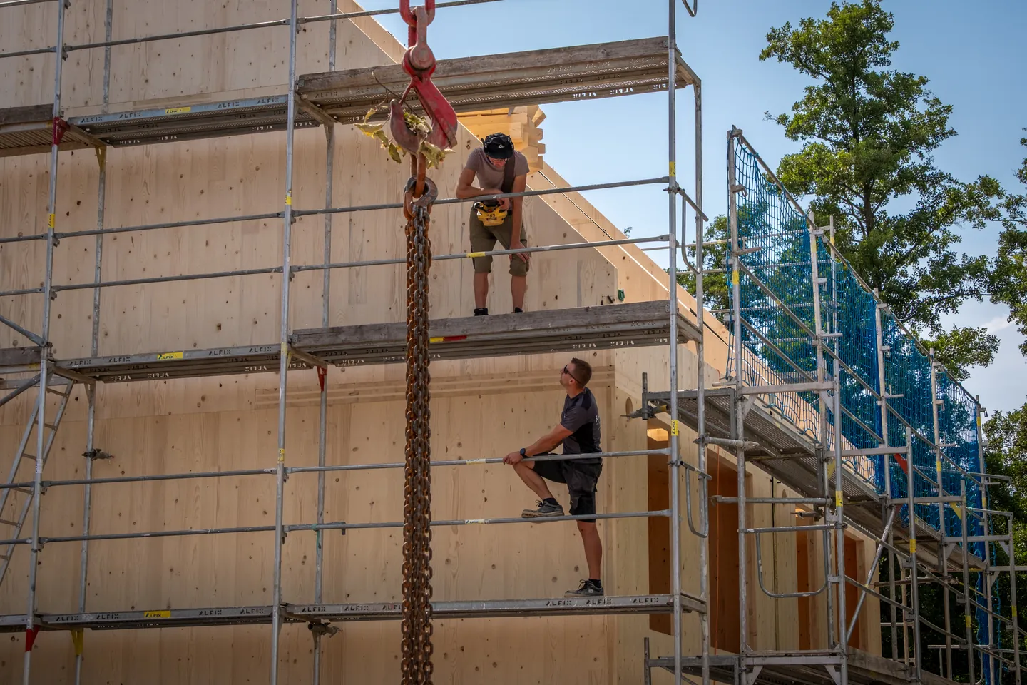 Monteure am Gerüst eines Holzbaus