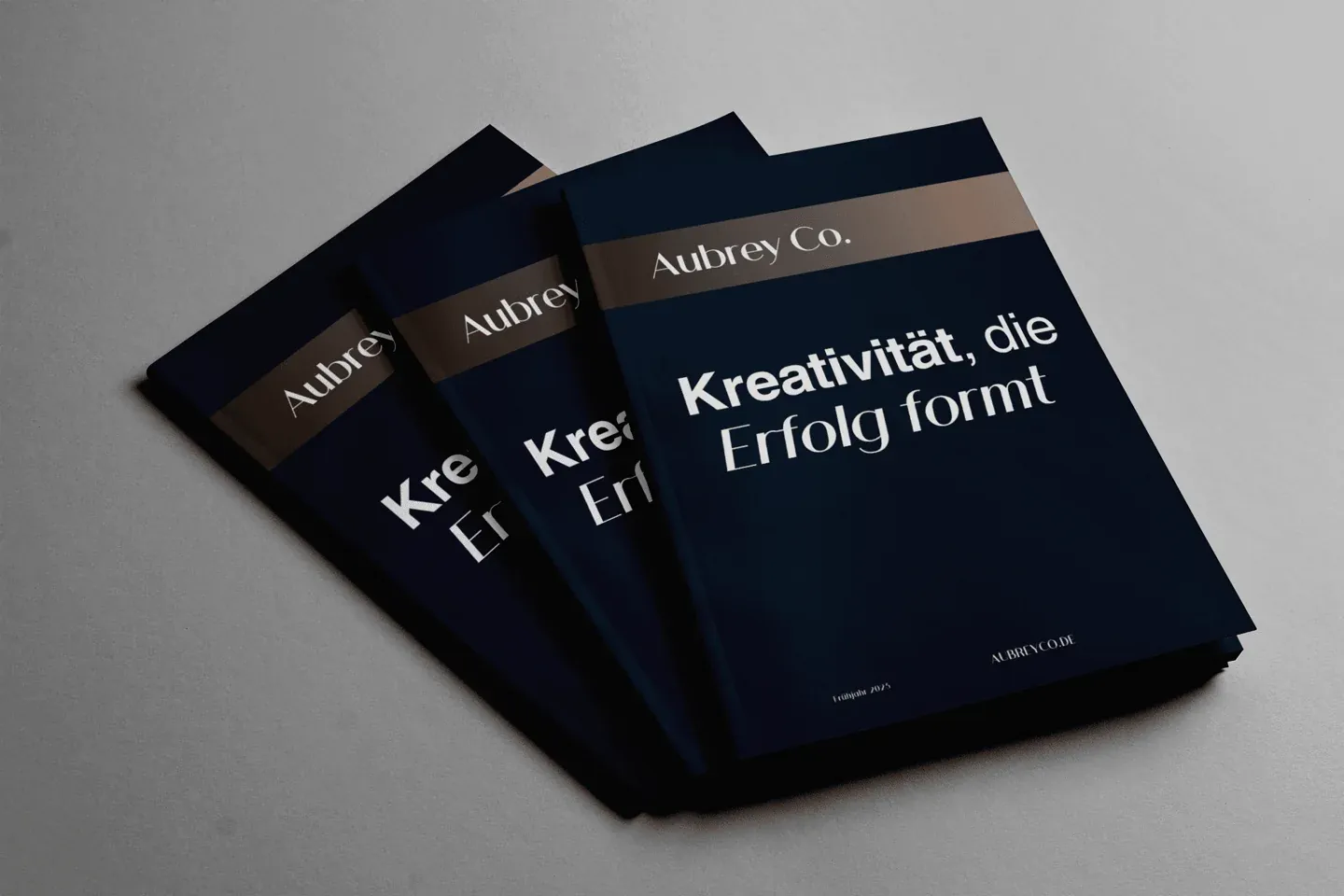 Drei Exemplare der Broschüre „Kreativität, die Erfolg formt“ von Aubrey Co.