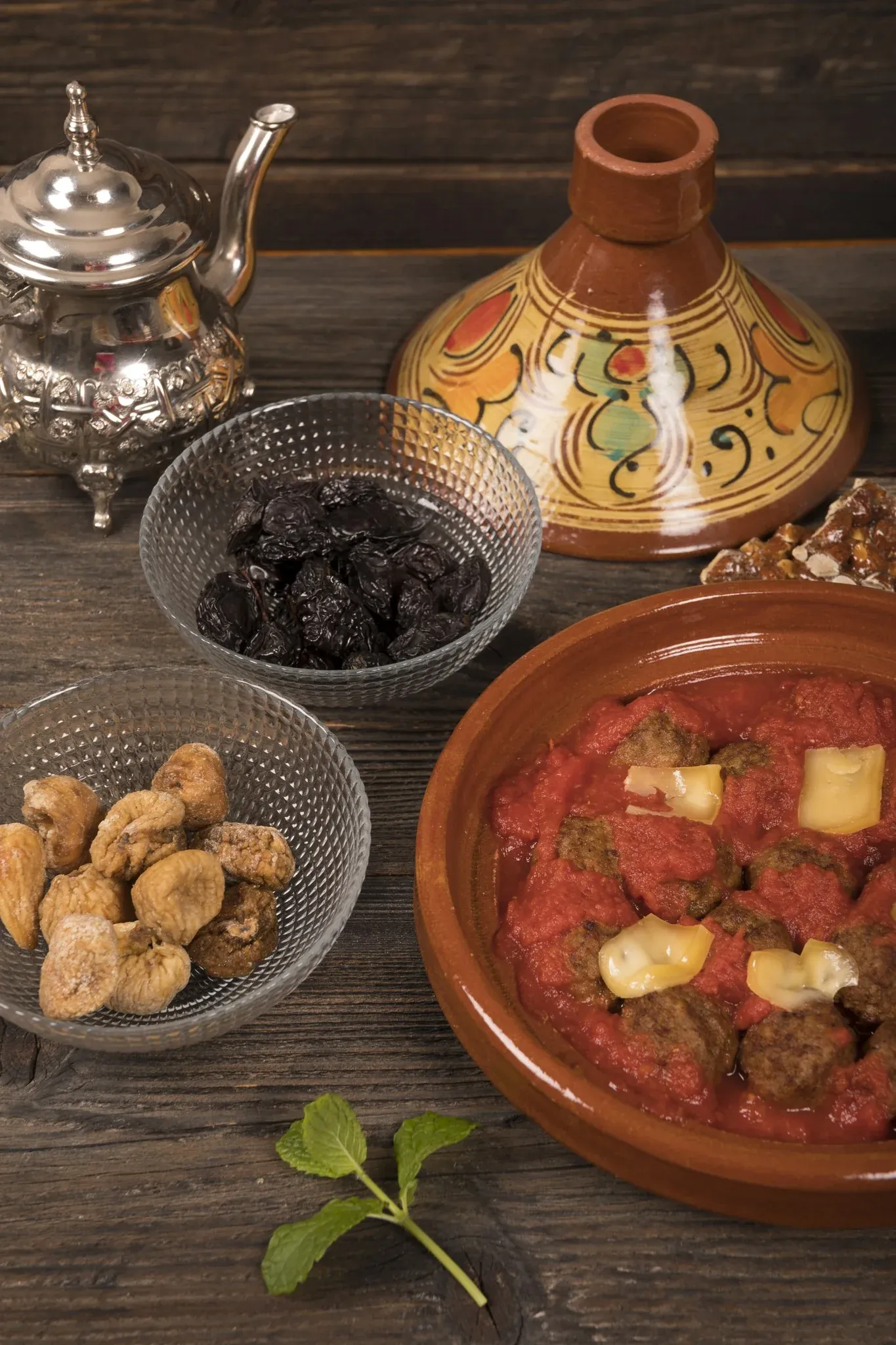 Tajine-Gerichte und Gewürze auf Holz